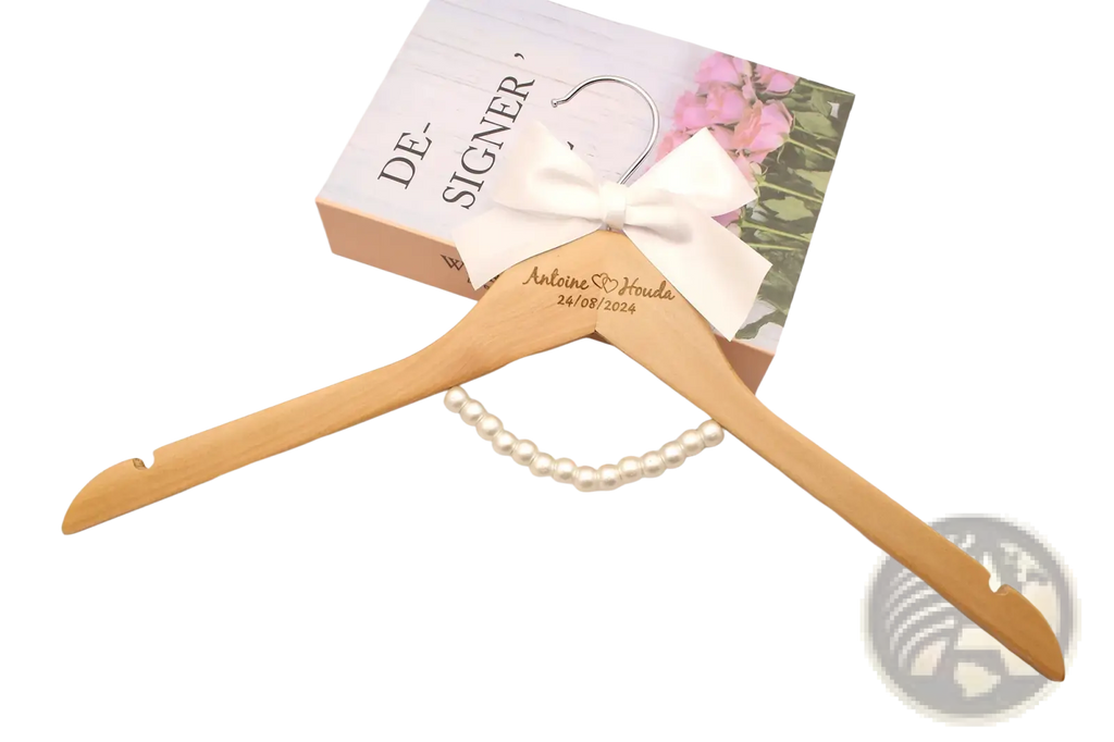 Personalized wedding dress hanger in light wood with white satin bow and engraved names and date for special occasions