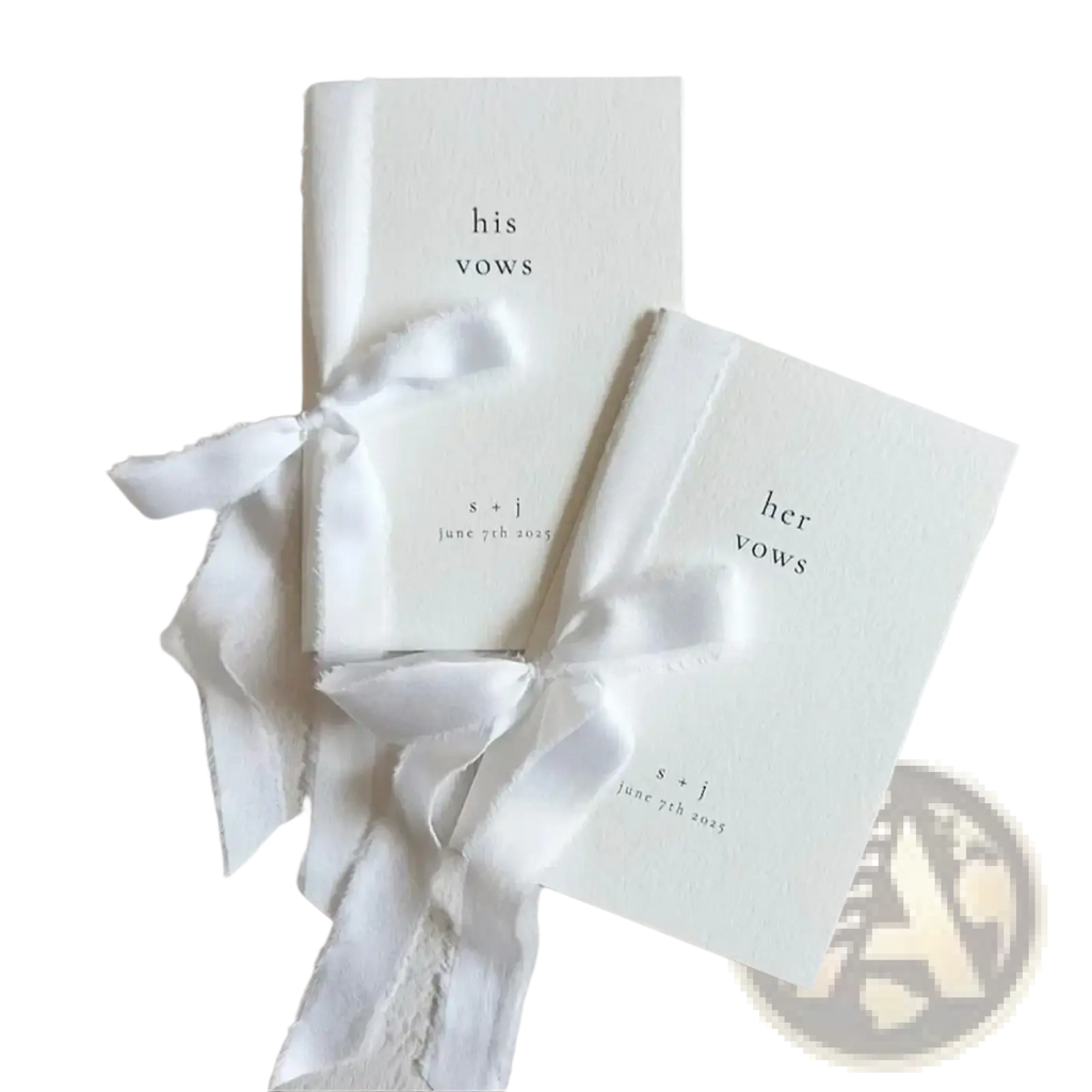 Two minimalist white personalized wedding vow books set his and her tied with delicate frayed ribbon bows