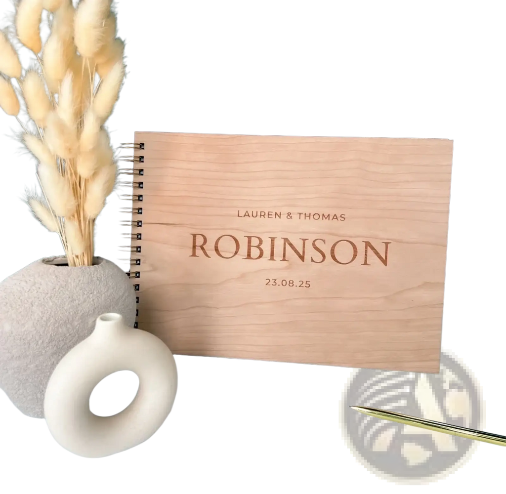 Light-colored wooden wedding guest book album with engraved names and date for personalized wedding keepsake