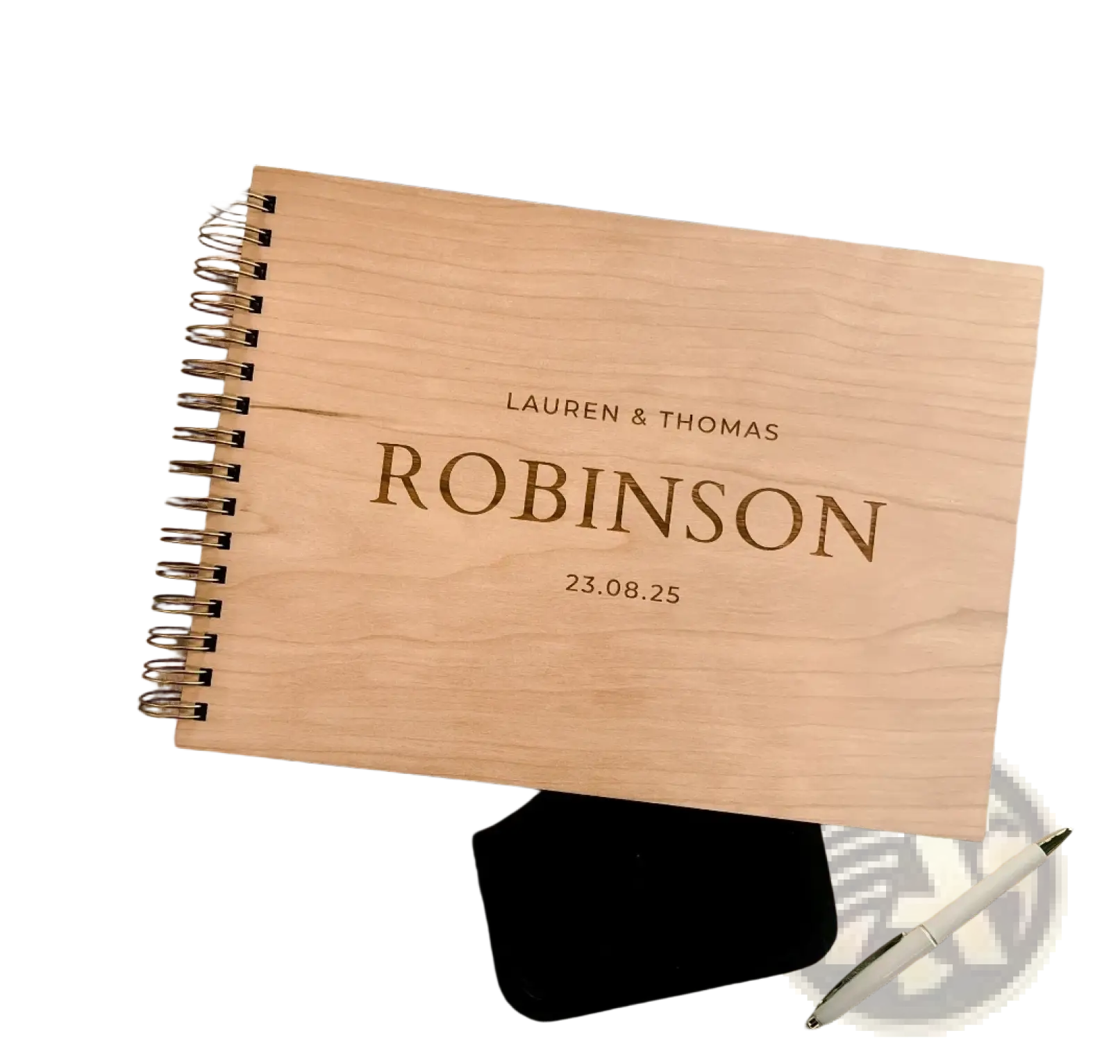 Personalized light-colored wooden spiral-bound wedding guest book album with engraved names and date