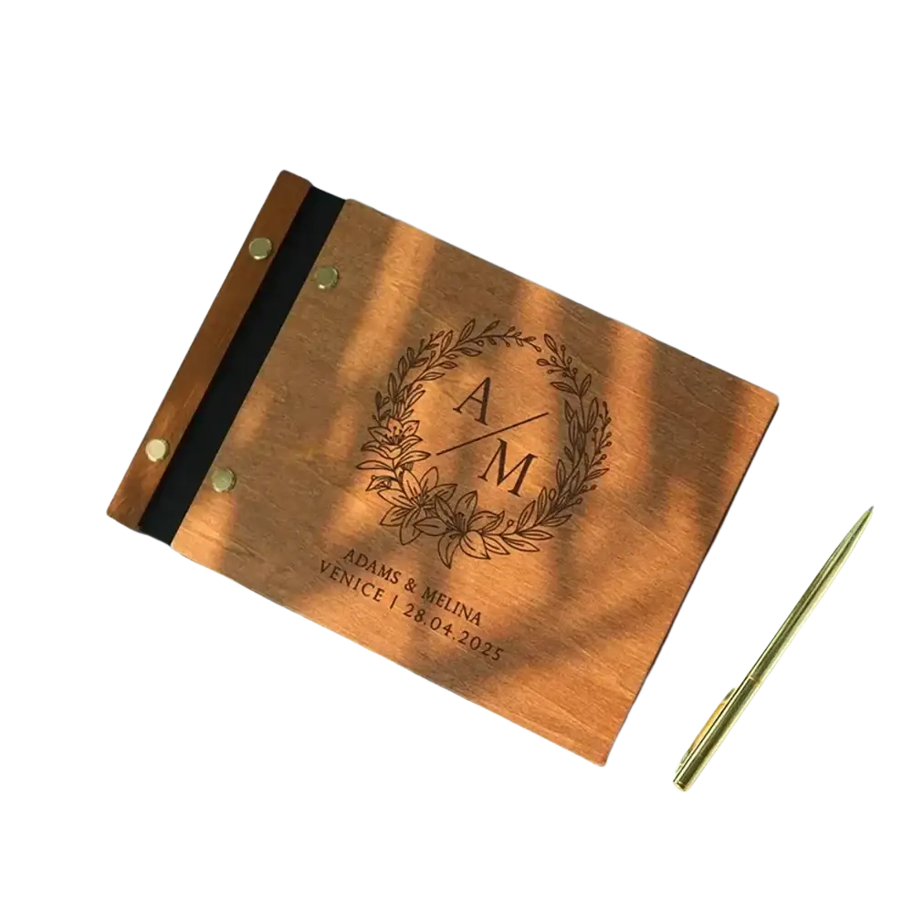 Personalized wooden wedding guest book with laser engraved monogram floral wreath and brass rivets along the spine