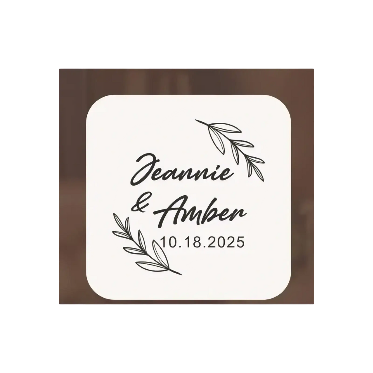 Cream-colored wooden wedding ring box coaster with rounded corners featuring black engraved text and leafy branch designs