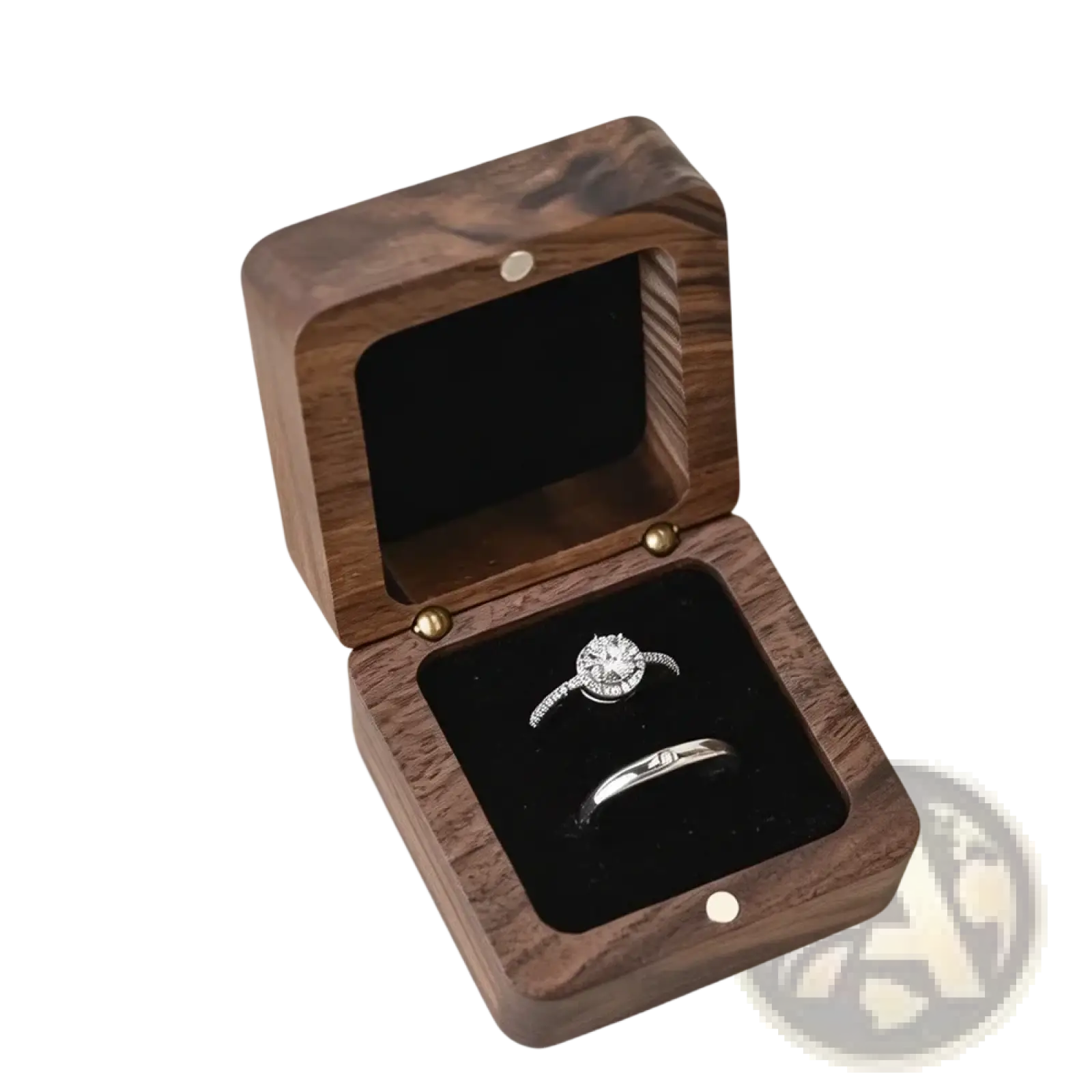 A personalized wooden wedding ring box in dark wood with a black velvet interior holding an engagement ring and band