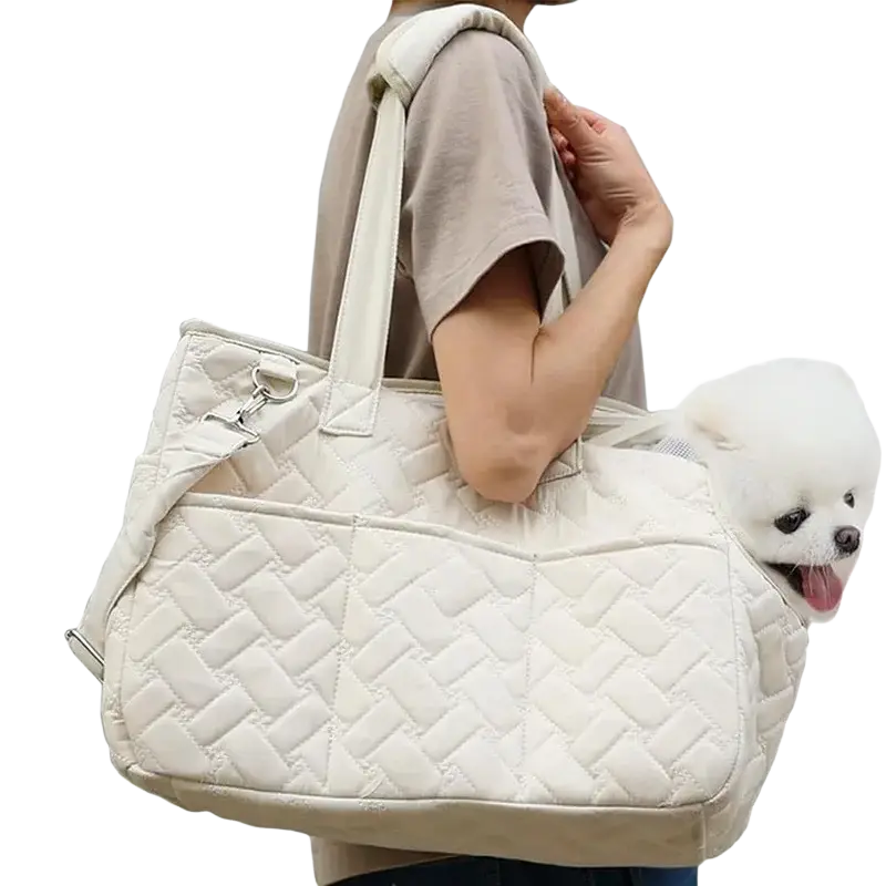 Cream-colored quilted pet bag with soft padded design and adjustable shoulder strap for small dog carrier use