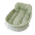 Cozy oval fabric pet bed with soft green and white gingham lining and tufted cushioning for small dogs