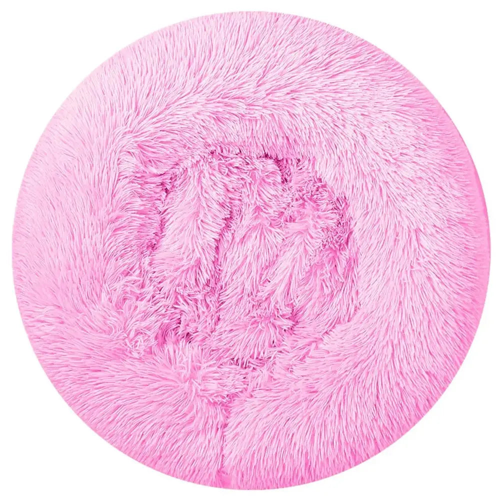 Pink circular faux fur rug with plush fluffy texture as a plush fleece donut pet bed for cats and small dogs