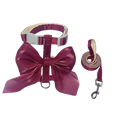 A shiny burgundy breathable pet harness and leash set with metallic silver buckle and bow detail