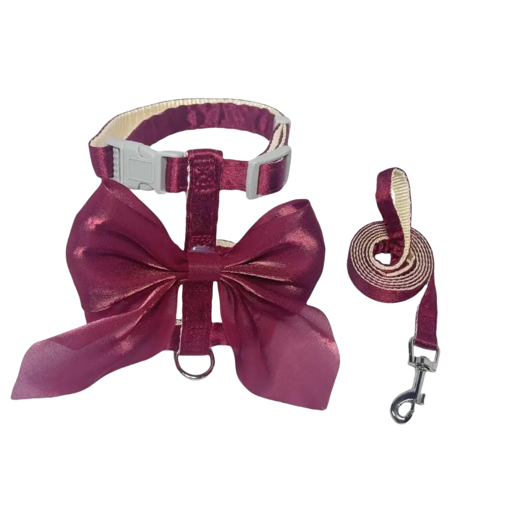A shiny burgundy breathable pet harness and leash set with metallic silver buckle and bow detail