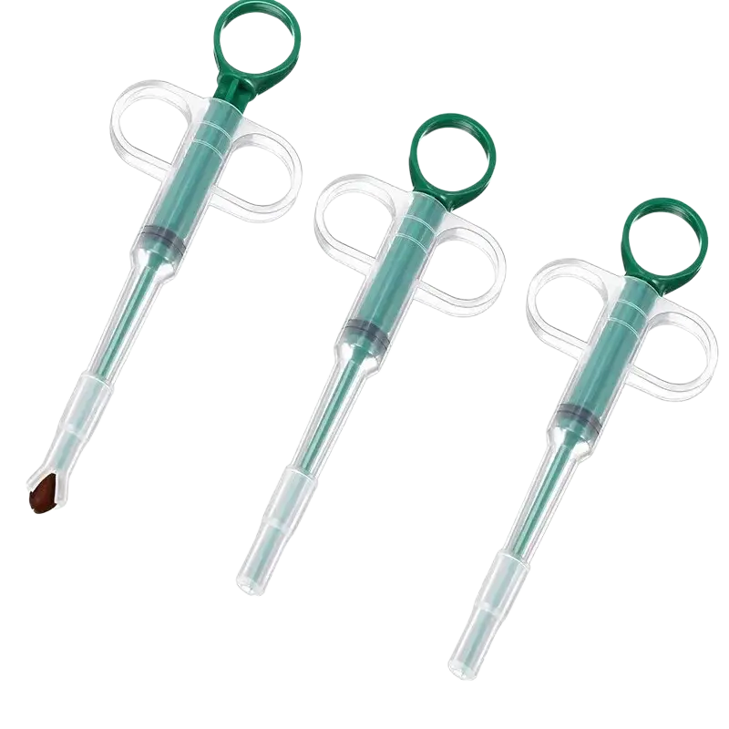 Three green and clear plastic pet pill dispensers with ring handles featuring a replacement head for medication delivery