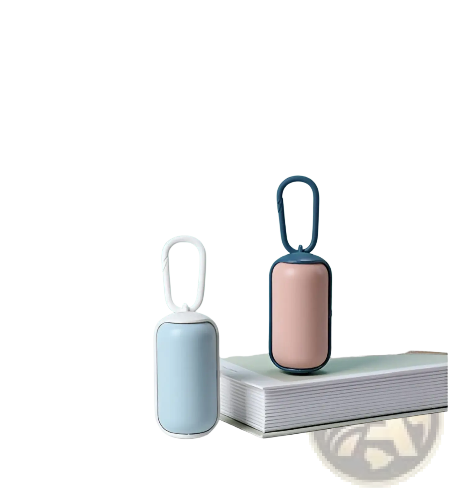 Two compact cylindrical pet poop bag dispensers in pastel blue and blush pink with metal carabiner clips for carrying