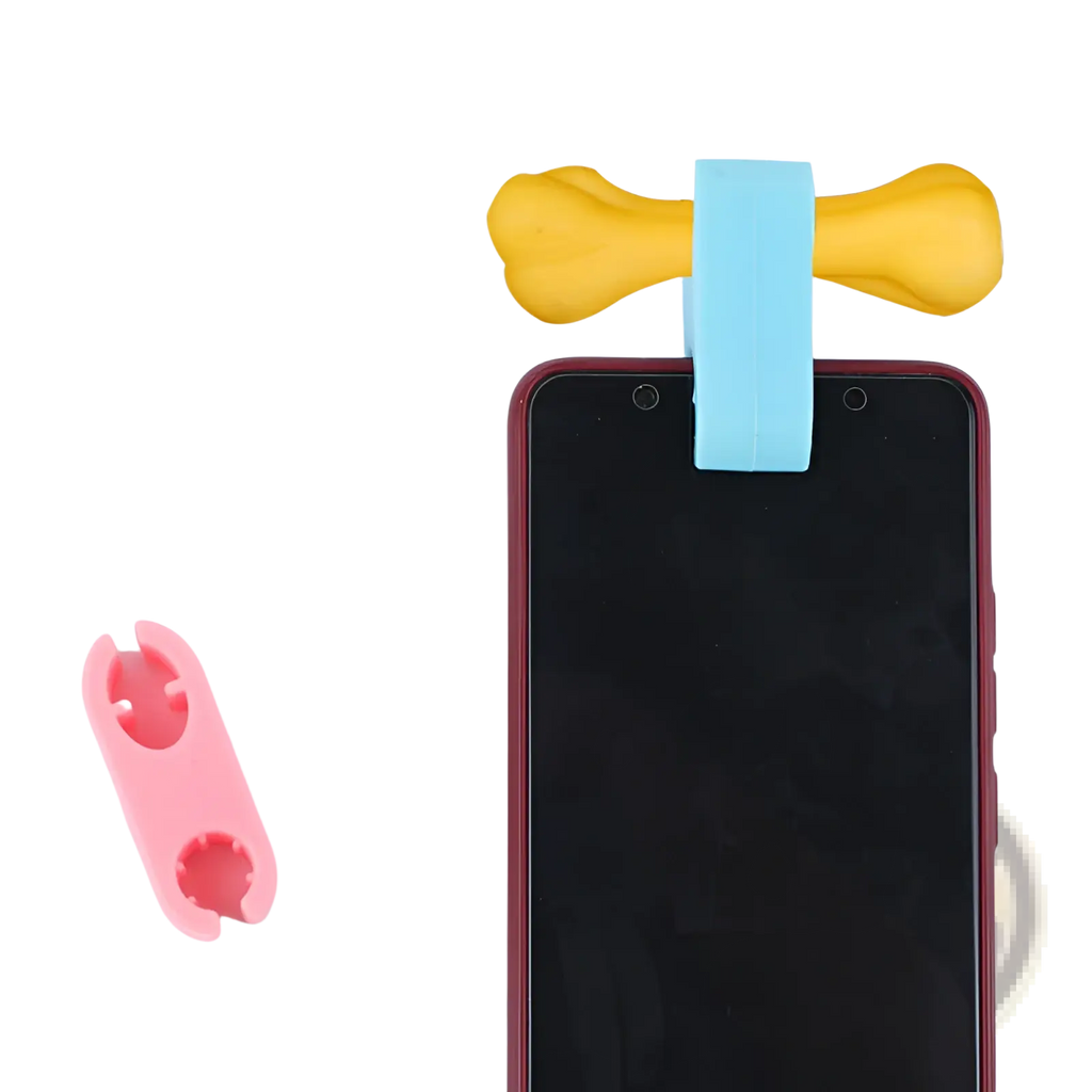 Yellow bone-shaped pet selfie phone clip with light blue silicone band for holding phones and dog toy set