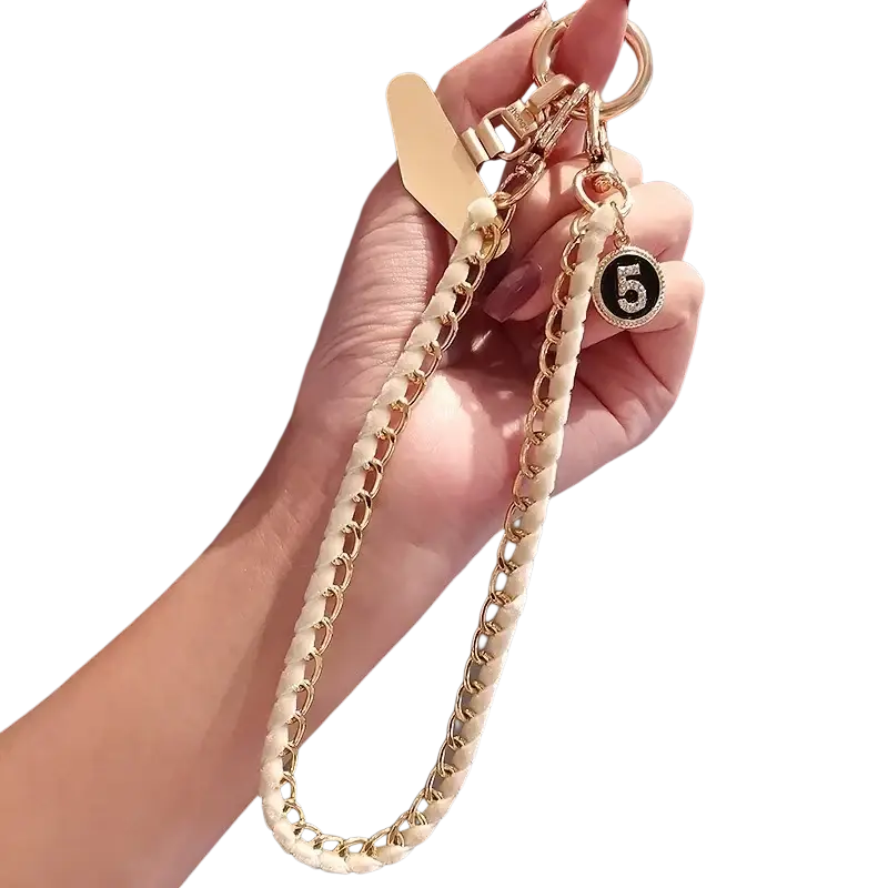 A cream-colored braided phone wrist strap gold chain with gold metal links and rhinestone number 5 charm