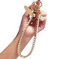 Phone wrist strap gold chain with white textured beads and floral charm for anti lost hand lanyard use
