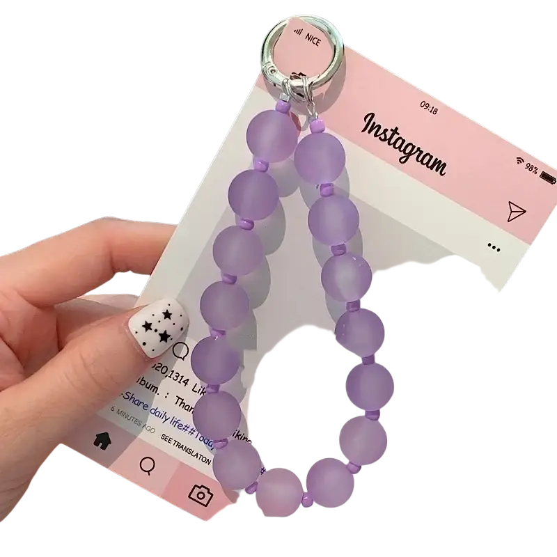 A delicate lavender jelly beaded phone wrist strap with a silver metal ring for secure carrying