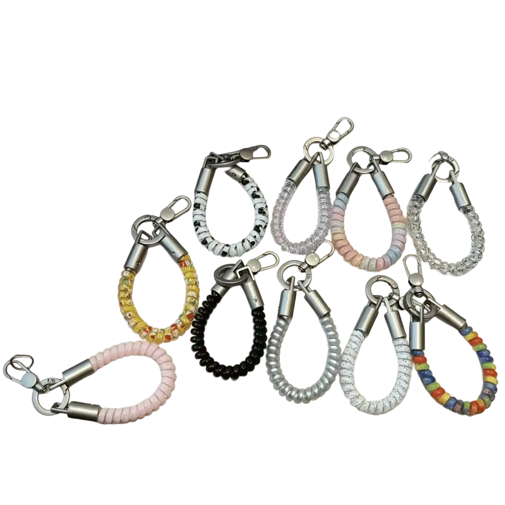 A collection of colorful coiled silicone phone wrist strap keychains with metallic silver clasps and hooks