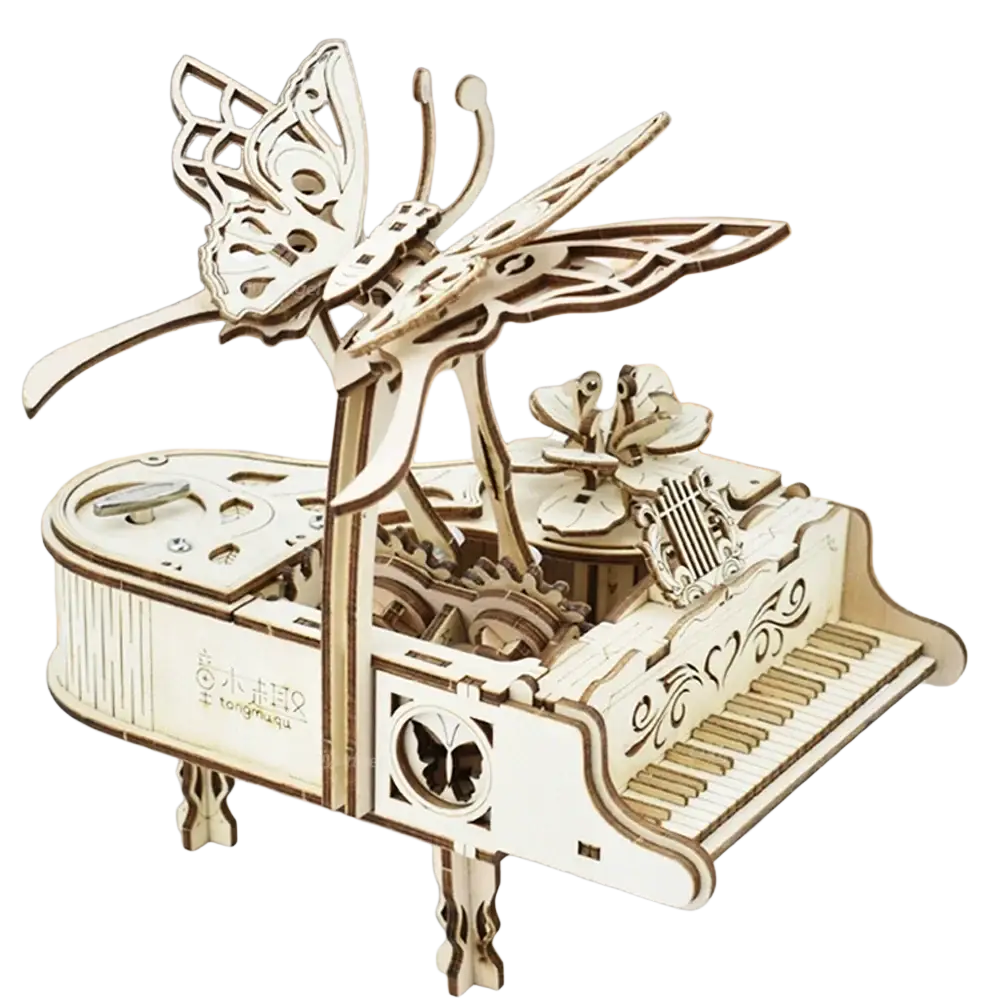 A delicate white wooden butterfly atop a laser-cut wood piano music box with intricate floral and mechanical details