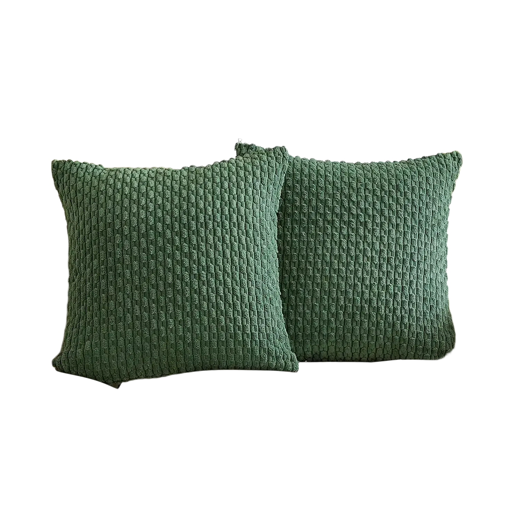 Two emerald green textured knit pillow covers on a cream corduroy cushion cover sofa for home decor