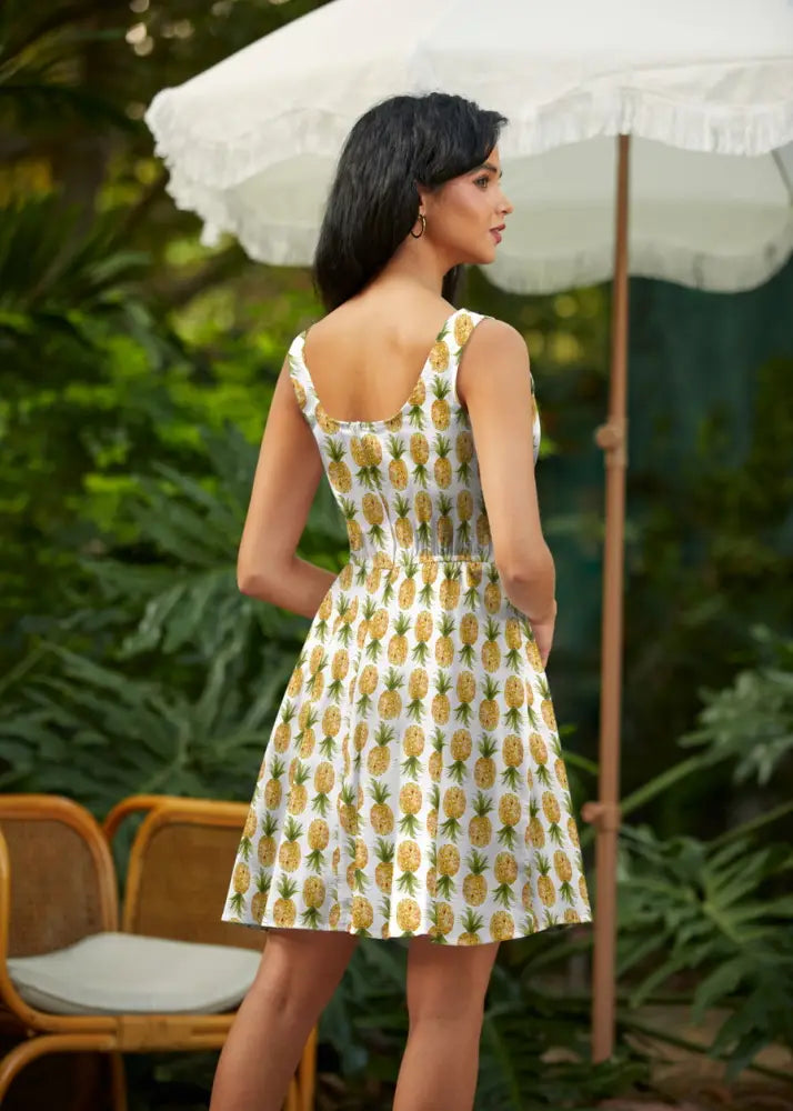 White pineapple print sleeveless skater dress with fitted bodice flared skirt and pockets for casual wear