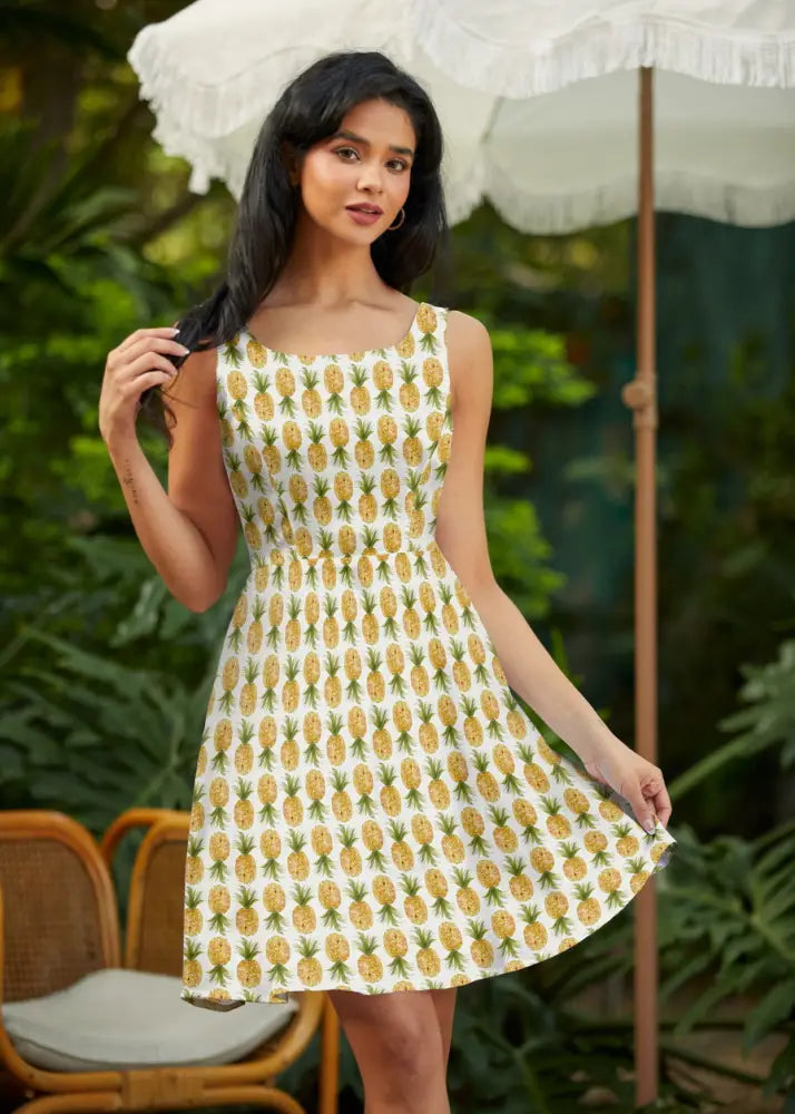 White pineapple print sleeveless skater dress with fitted bodice flared skirt and pockets in lightweight fabric