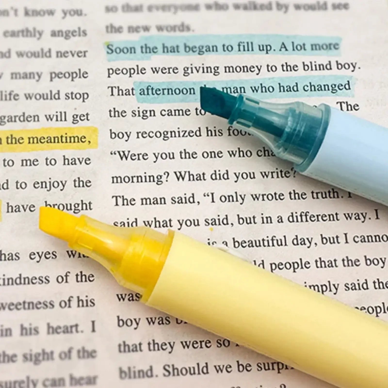 A yellow and teal highlighter pen resting on a page with highlighted text from the pink 11 piece student stationery set
