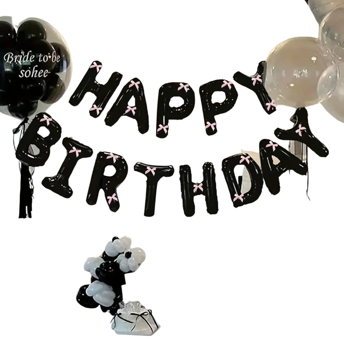 Black happy birthday balloon banner with pink bow accents for party decoration set