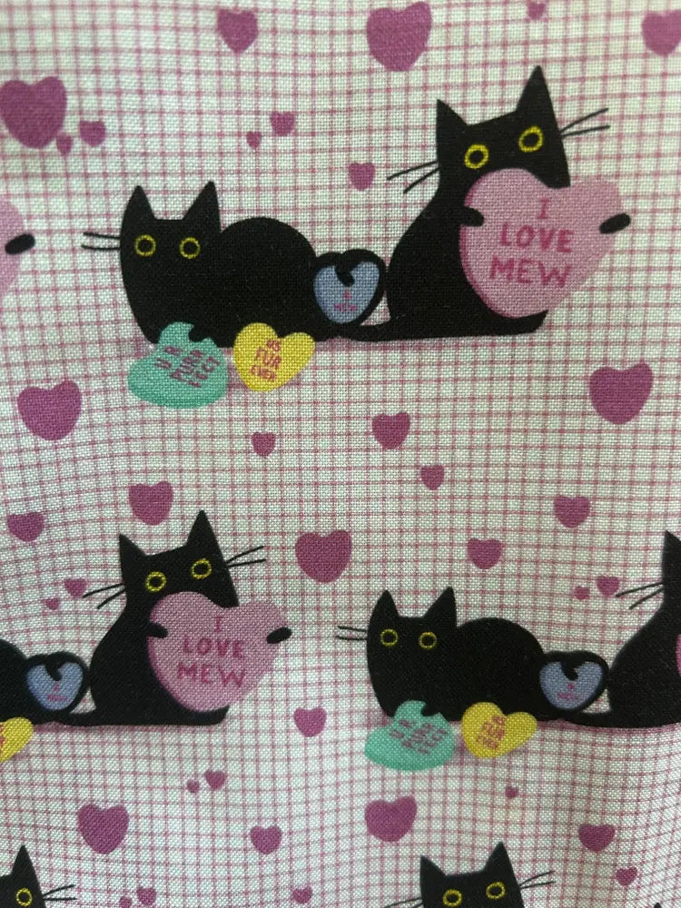 Pink cats and hearts checkered skater skirt featuring black cartoon cats with yellow eyes holding colorful heart candies on light pink fabric
