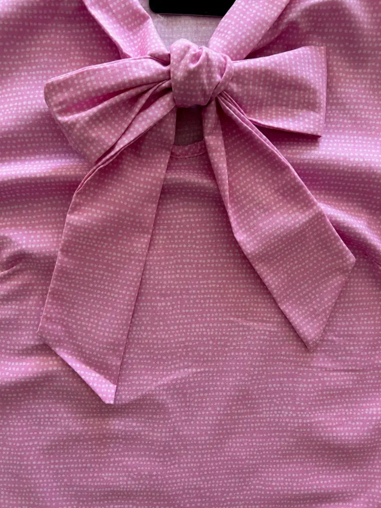 Vintage pink polka-dot sleeveless cotton blouse with a large bow at the neckline for stylish casual wear