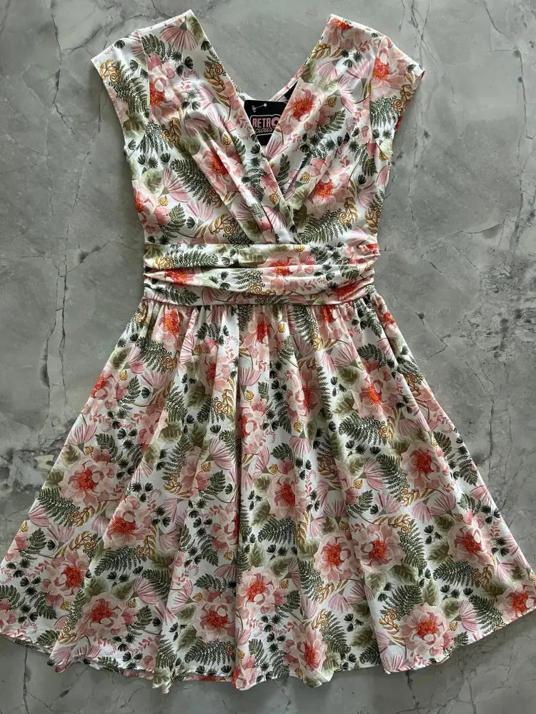 Pink floral greta vintage cotton knee length dress with sleeveless v-neckline and cinched waist featuring pink blossoms and green ferns