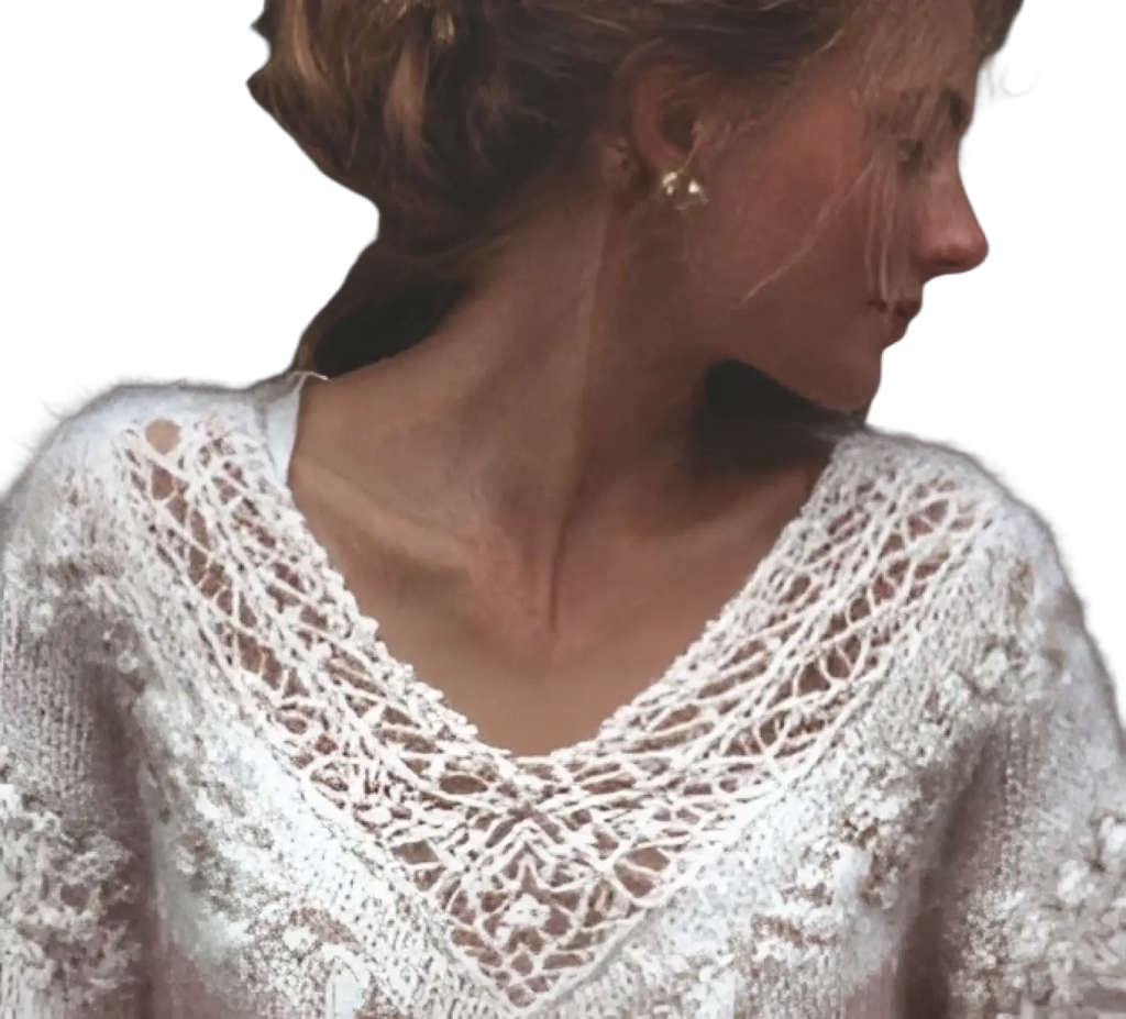 A delicate white knitted sweater with lace detailing around the neckline and shoulders in a pink gradient style