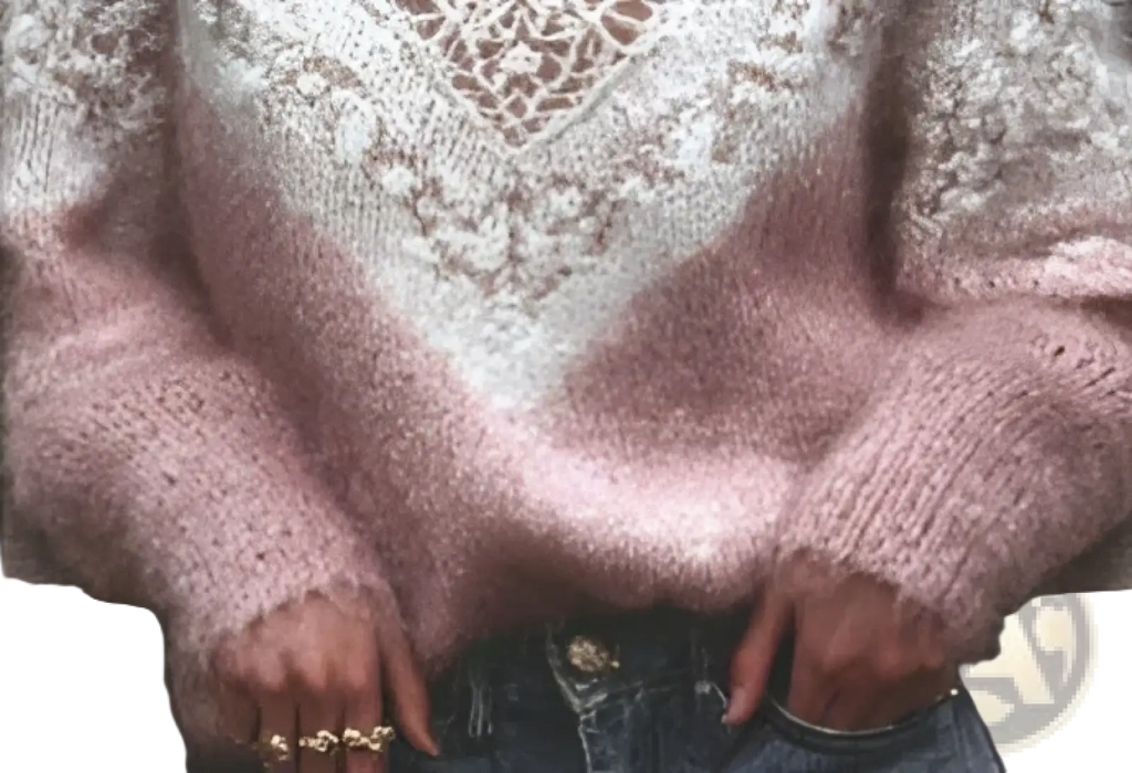 A soft pink fuzzy knit v-neck sweater with a delicate white lace pattern across the chest and shoulders