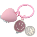 Pink heart smiley face keychain featuring a pink heart-shaped keychain with a smiling face charm attached