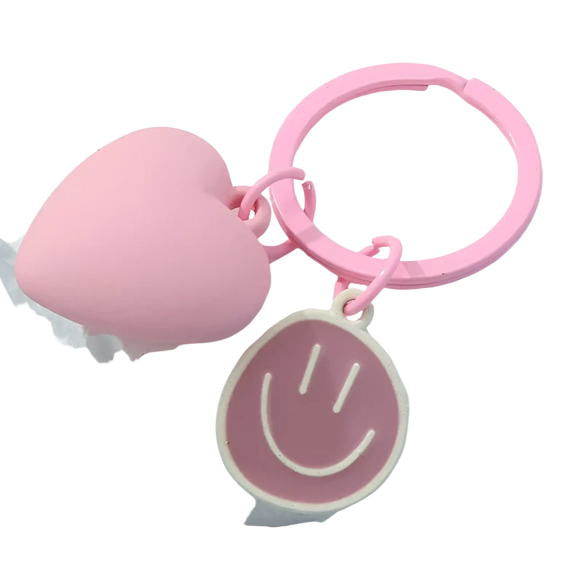 Pink heart smiley face keychain featuring a pink heart-shaped keychain with a smiling face charm attached