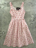 Pink sleeveless fit and flare dress with pockets featuring a vintage style poodle print in varying pink and white shades