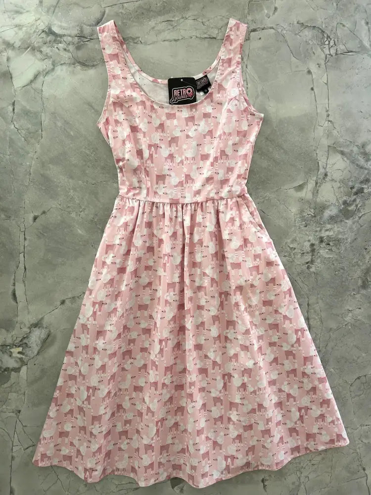 Pink sleeveless fit and flare dress with pockets featuring a vintage style poodle print in varying pink and white shades