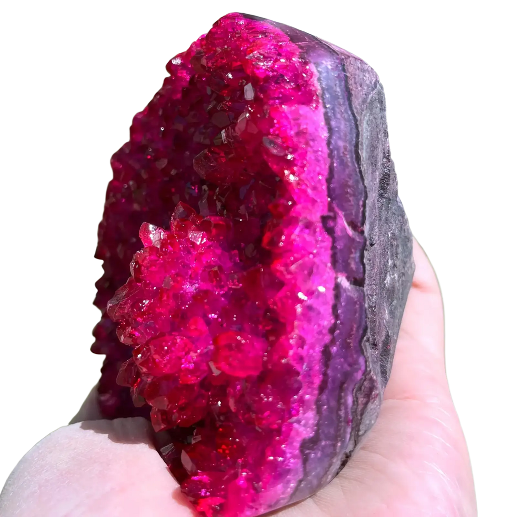 A vibrant pink quartz geode crystal cluster with sparkling purple formations for home decor