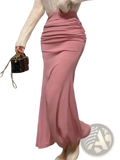 A soft pink ruched high waisted mermaid midi skirt with flowing fabric and a comfortable ruched waistband
