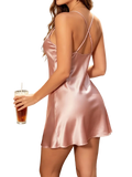 A soft pink satin crossback slip dress with delicate crisscross straps and a flared hem for elegant wear