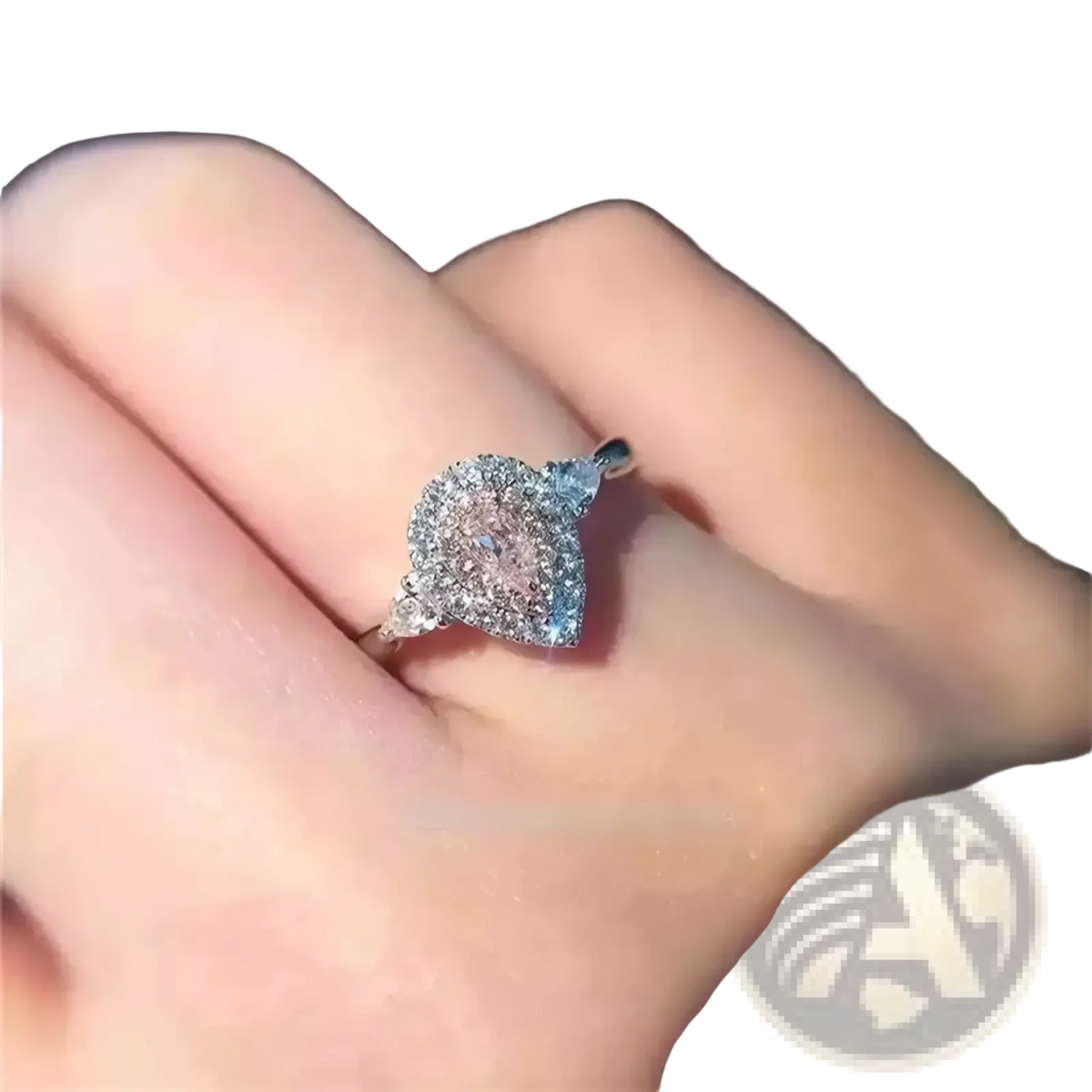A pink teardrop zircon engagement ring with a sparkling centerpiece set in a sleek silver pavé band