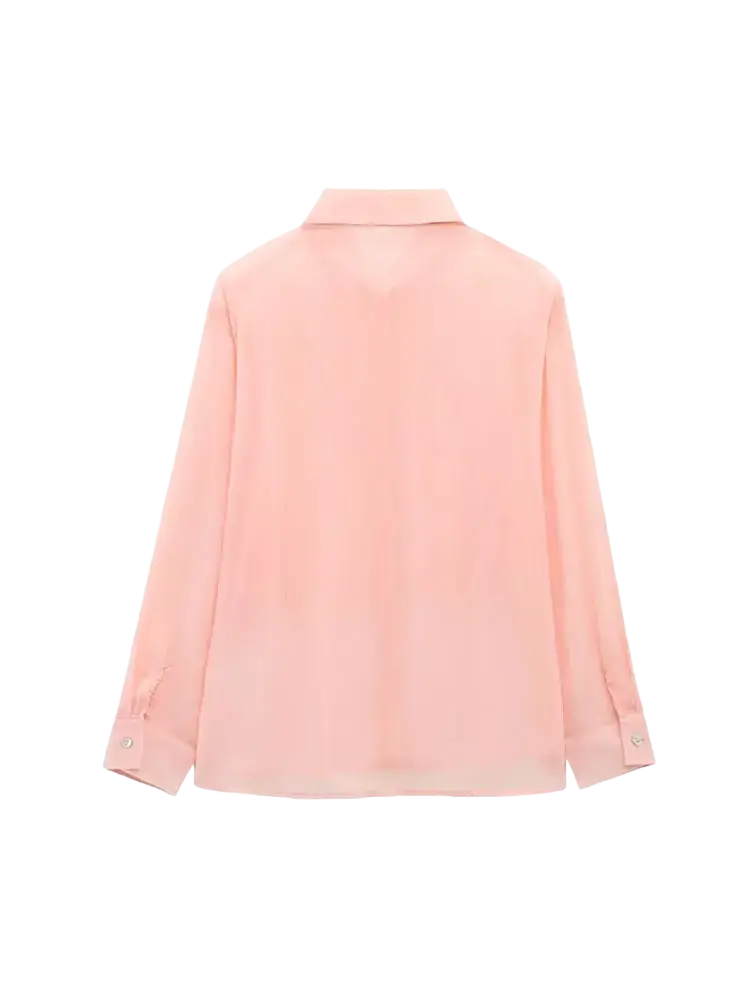 A soft pink textured ruffled button up blouse with long sleeves and a classic collar featuring a subtle sheen