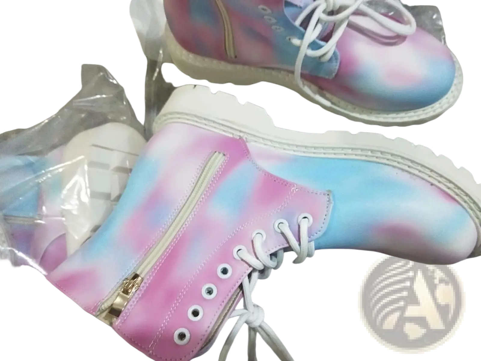 Pink tie dye combat boots with pastel pink and blue pattern, chunky white sole, white laces, and gold zipper