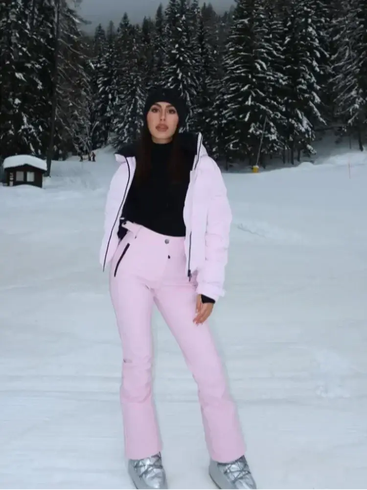 Pink waterproof women ski suit featuring hooded winter snowwear with pink ski pants and black zipper accents