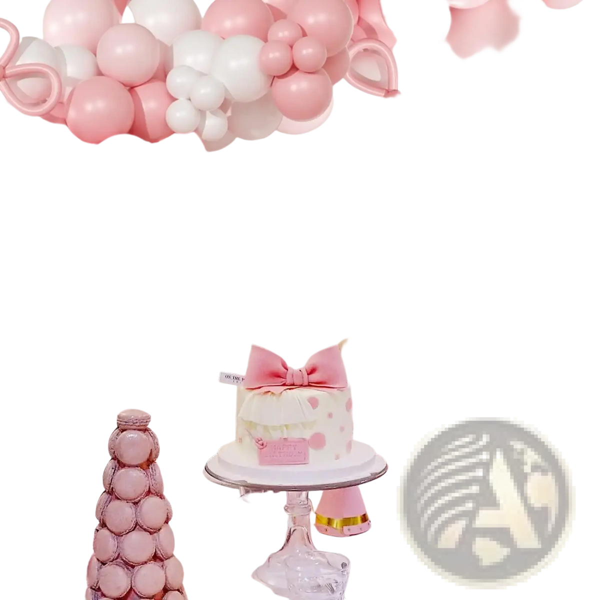 A delicate white cake decorated with a pink bow and polka dots topped with a small pink plaque for dessert display
