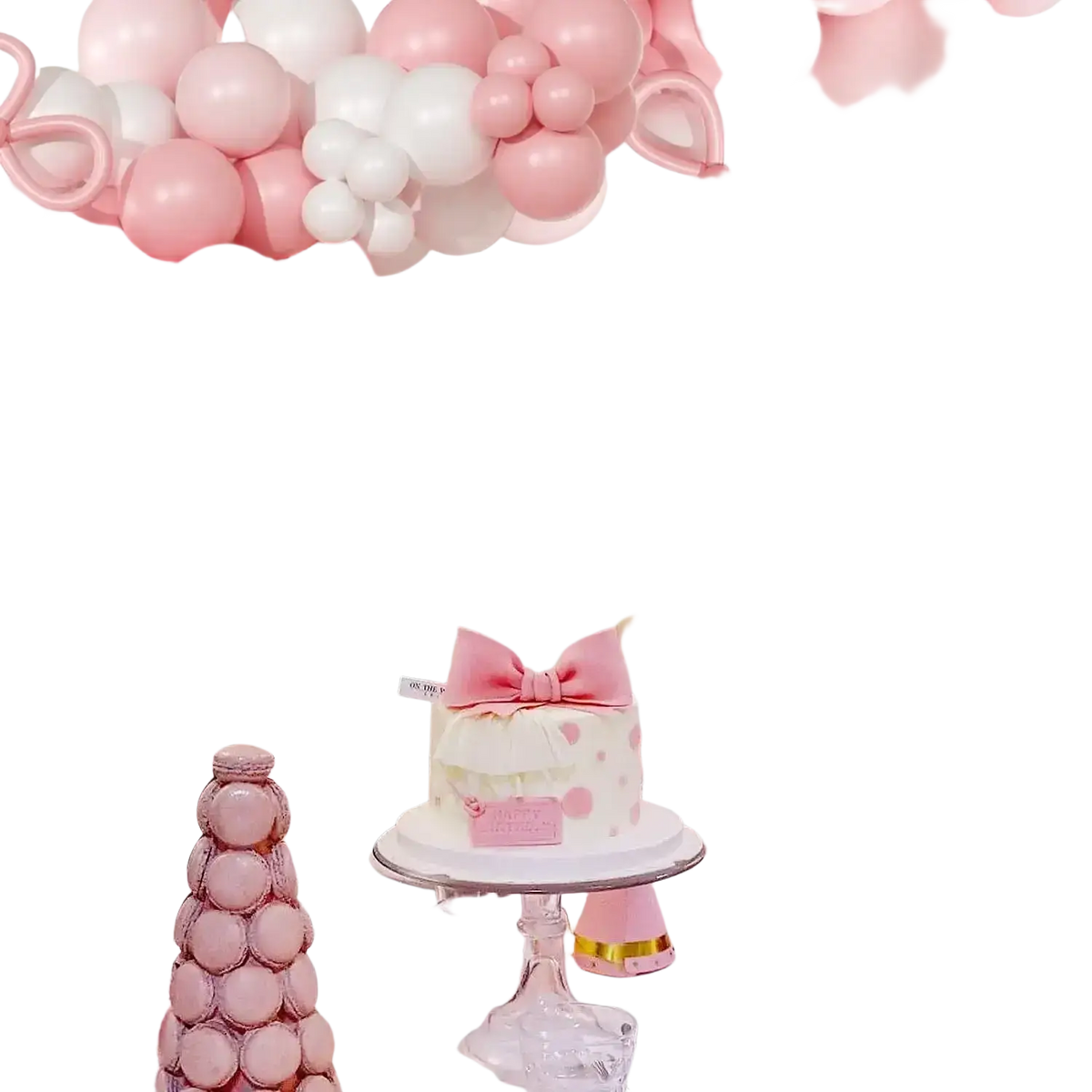 A delicate white cake with pink bow and polka dots on a glass stand complements the pink white bow balloon garland arch kit