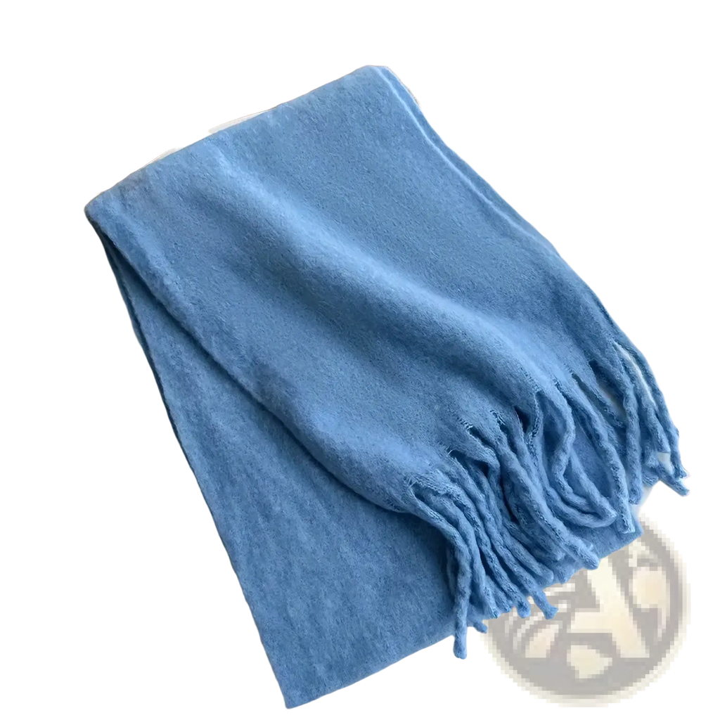 Pink winter cashmere scarf for women featuring a soft light blue knit with fringed edges neatly folded on a white table