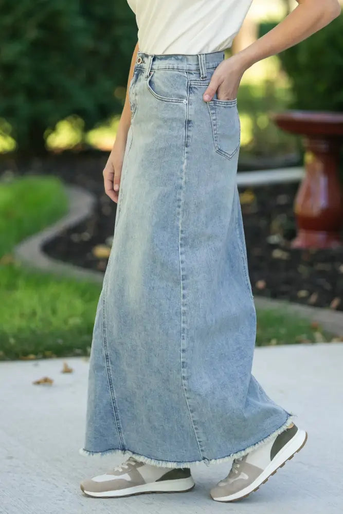 Piper light wash a-line denim maxi skirt with frayed hem and classic front pockets in light-wash denim