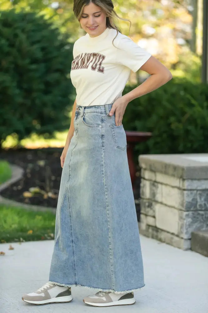 Piper light wash a-line denim maxi skirt with high waist front pockets and frayed hem in light-wash denim