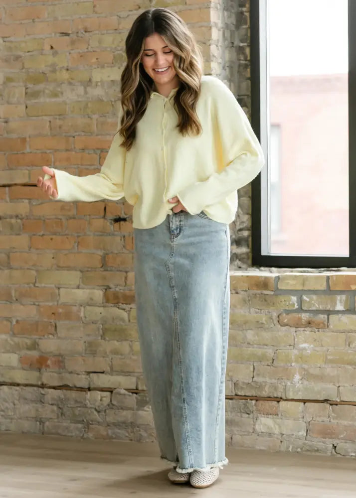 Piper light wash a line denim maxi skirt with frayed hem paired with a soft pale yellow knit button up sweater