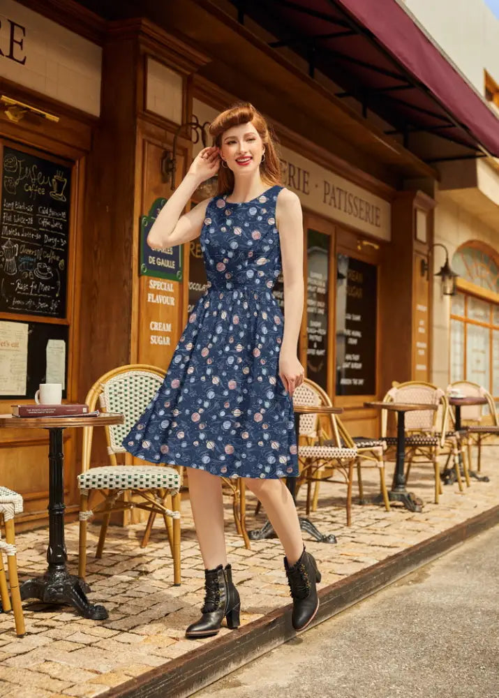 A navy blue sleeveless vintage 1950s cotton dress with pink and white floral pattern and a fitted bodice
