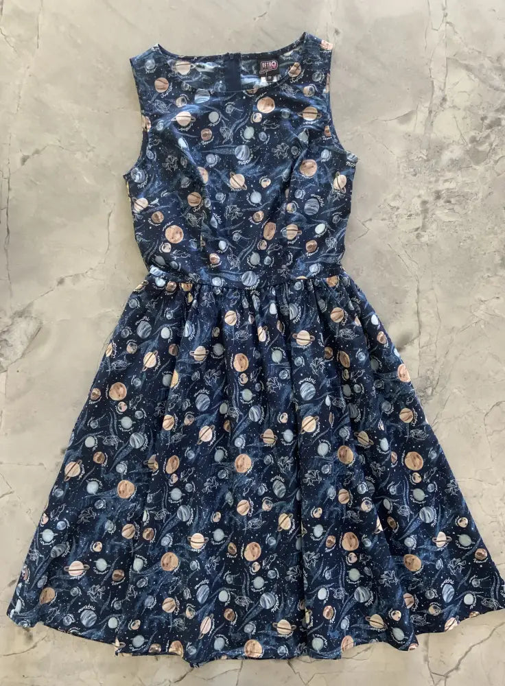 A vintage 1950s navy celestial cotton a-line dress with pockets featuring a playful space-themed planet print