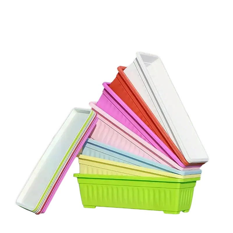 A stack of colorful rectangular plastic planting pots in lime green pink orange and white for plants